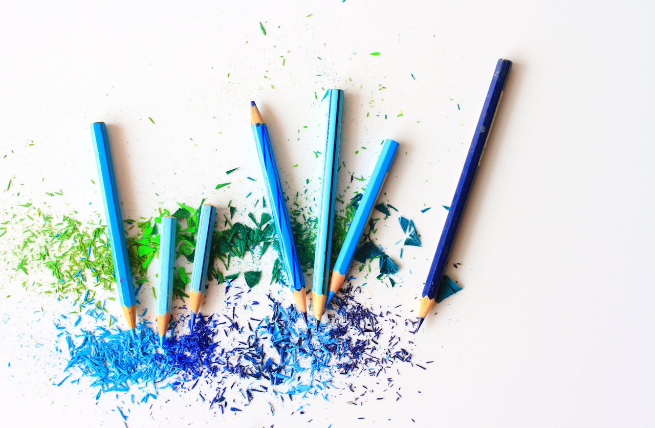 services-04 Creative display of colored pencils and vibrant shavings on a white background.