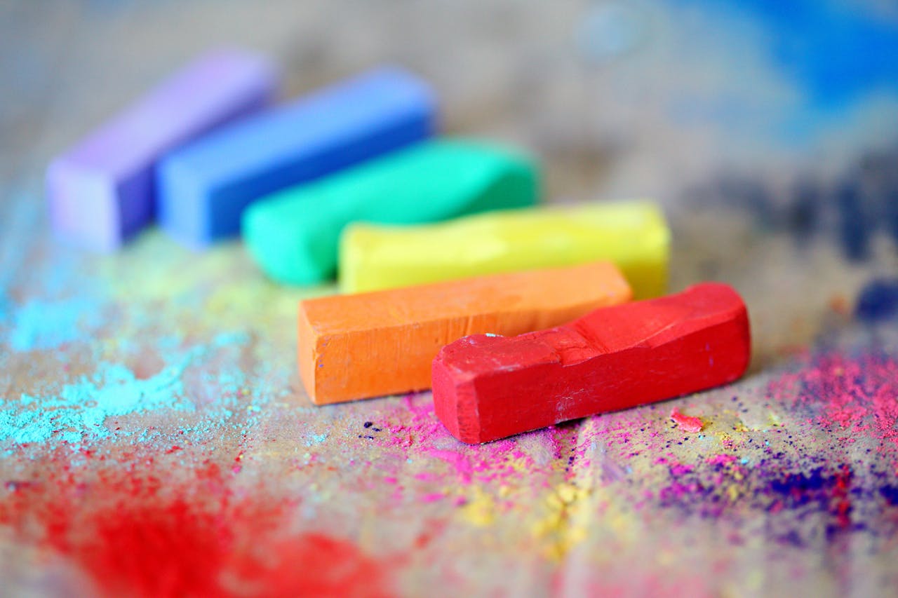 services-03 Vibrant pastel chalks on colorful splattered canvas, perfect for creative arts and crafts inspiration.