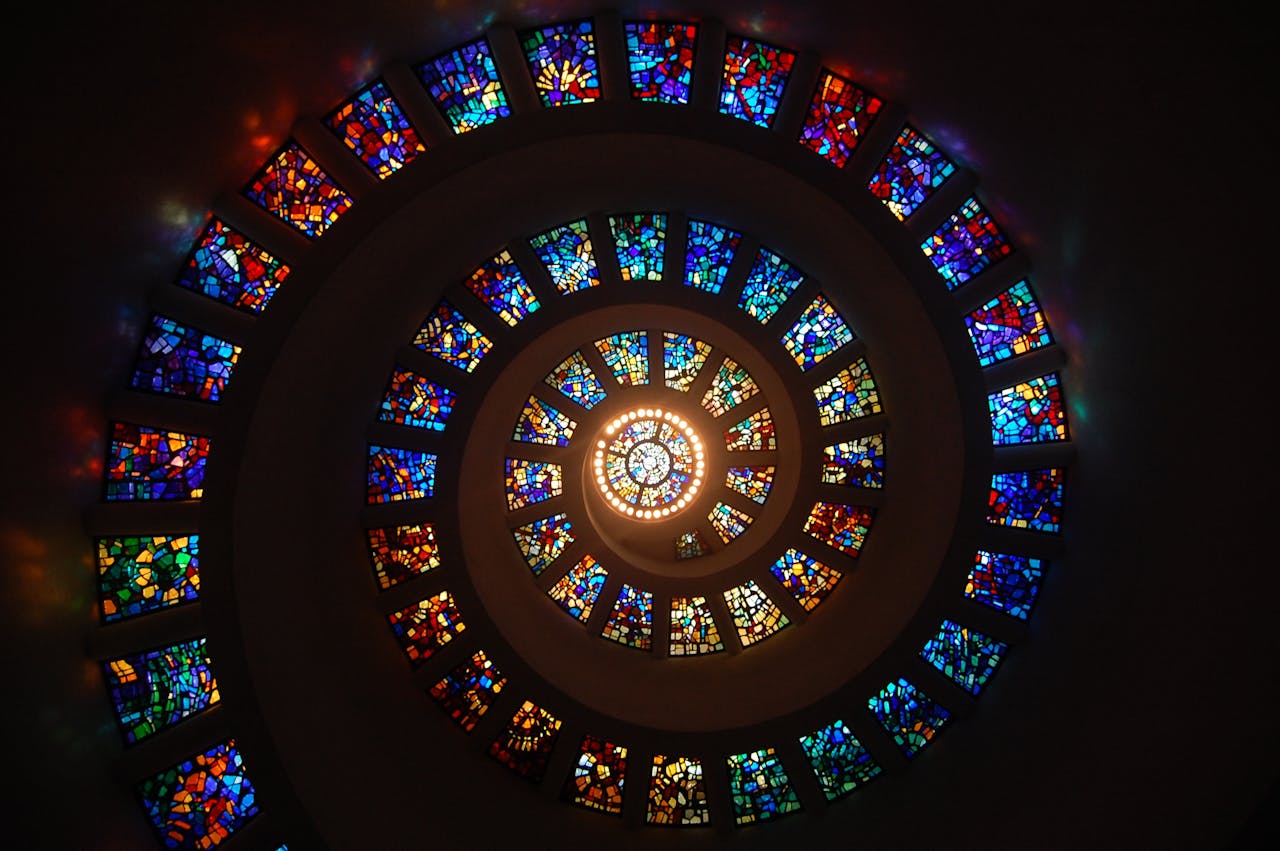 heros-img Captivating spiral stained glass art with vibrant colors forming a dramatic eye-catching pattern.